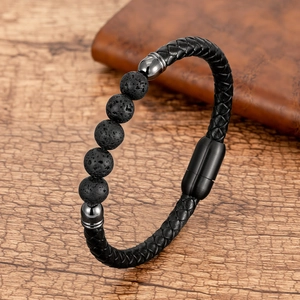 Detalle macro de pulsera de cuero trenzado negro con cuentas de lava sobre madera