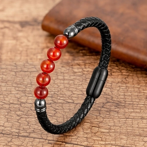 Detalle de pulsera de cuero trenzado con cuentas de ágata roja y cierre magnético negro