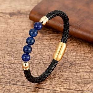 Detalle de pulsera de cuero trenzado negro con cuentas azules y cierre magnético dorado