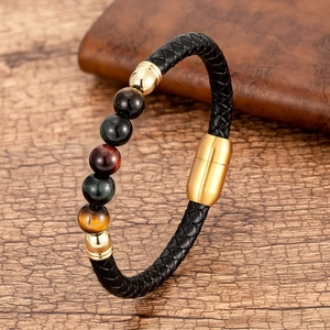 Detalle de pulsera de cuero trenzado con cuentas de ojo de tigre sobre madera