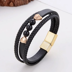 Close-up of multilayer leather bracelet with black beads and rose gold heart charms