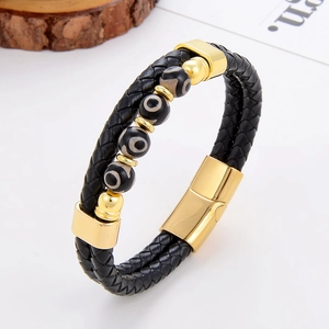 Détail du bracelet en cuir tressé noir avec perles à œil et fermoir magnétique doré poli