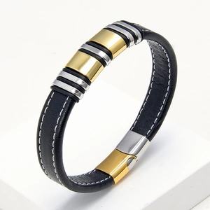 Detailed view of black woven leather bracelet with gold and silver steel tubes and white stitching