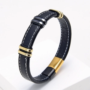 Primer plano de pulsera de cuero negro con cierre magnético de acero inoxidable dorado