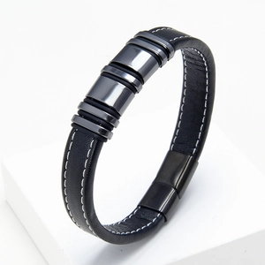 Detail of black woven leather bracelet with contrast stitching and gunmetal magnetic clasp