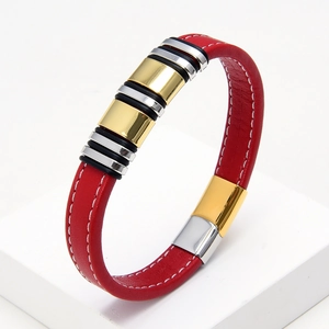 Detail of red braided leather bracelet with silver and gold metal cylinder accents