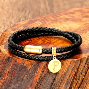 Detail of black double-layered braided leather bracelet with gold magnetic clasp and P pendant
