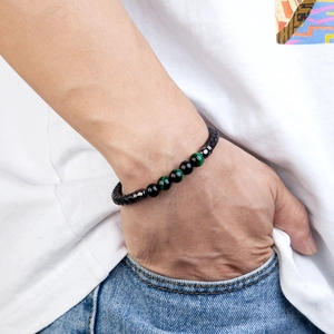Pulsera de cuero trenzado para hombre con cuentas de ojo de tigre puesta en la muñeca
