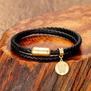 Detail of double-layer woven black leather bracelet with crystal letter W gold charm
