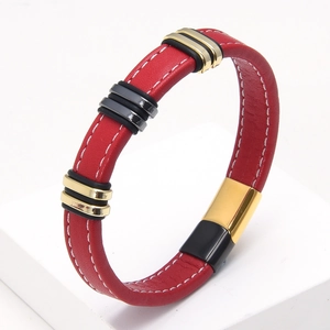 Detalle de pulsera de cuero trenzado rojo con anillos dorados y cierre magnético