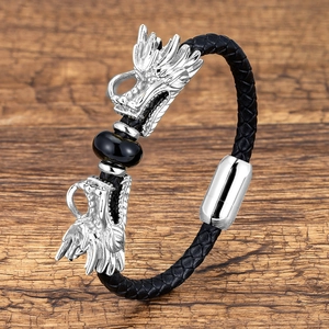Detail of silver double dragon head buckle on black braided leather men's bracelet