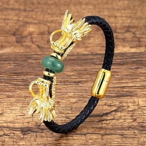 Close-up of men's braided leather bracelet featuring golden dragon heads and a green bead