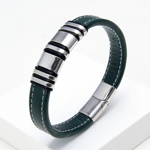 Detail of dark green braided leather bracelet with silver metal rings and magnetic clasp