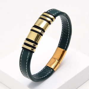 Detail view of dark green braided leather bracelet with golden metal accents and white stitching