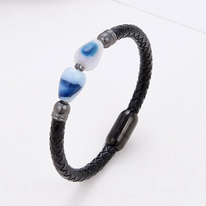 Close-up of black braided leather bracelet with blue stone beads and matte metal magnetic clasp