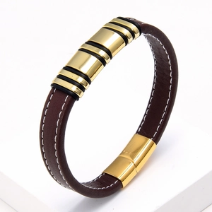 Macro detail of brown braided leather bracelet with golden metallic accents and magnetic clasp