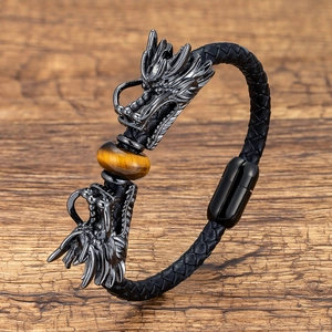Macro detail of braided leather bracelet with twin dragon heads and tiger eye stone
