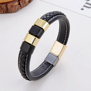 Vue détaillée d'un bracelet en cuir tressé noir pour homme avec détails en métal doré et fermoir