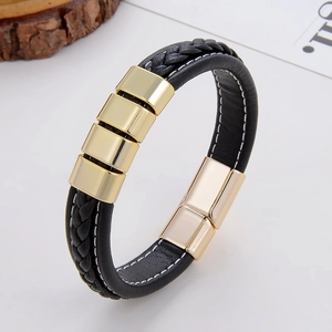 Détail d'un bracelet en cuir noir tressé avec curseurs dorés et boucle magnétique