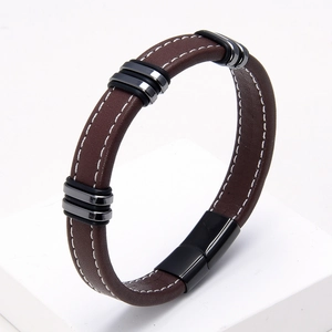Detalle de la pulsera de cuero marrón trenzado con cierre magnético negro y costuras blancas
