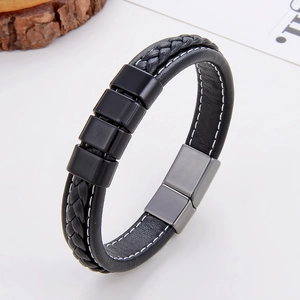 Détail du bracelet en cuir tressé noir avec perles décoratives et fermoir magnétique