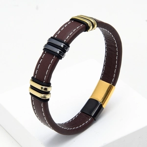 Detalle de la pulsera de cuero trenzado marrón con cierre magnético dorado y negro