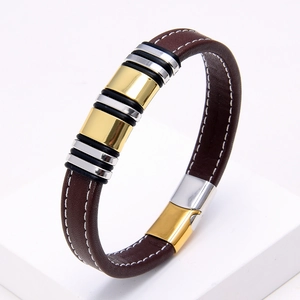 Detail of dark brown braided leather bracelet with gold and silver metal rings