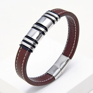 Detail of brown leather bracelet with white stitching and silver stainless steel accents