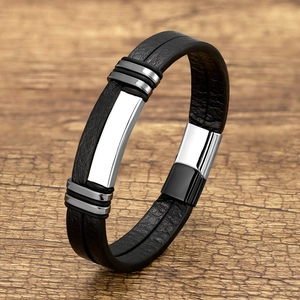 Macro detail of men's leather bracelet with stainless steel plate on wooden surface