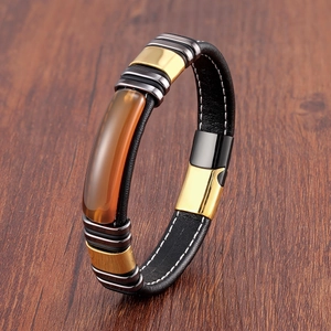 Gros plan d'un bracelet en cuir pour homme avec pierre ambre sur une table en bois