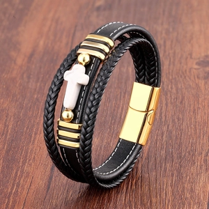 Gros plan d'un bracelet en cuir multicouche avec une croix en marbre et fermoir aimanté