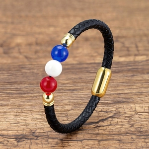 Detailed view of woven black leather bracelet with three-color beads and magnetic gold clasp