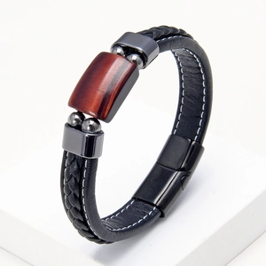 Dettaglio del bracciale in pelle intrecciata con pietra occhio di tigre e chiusura magnetica