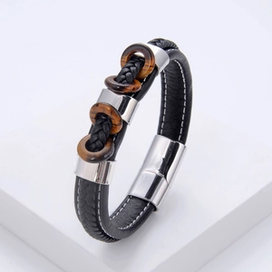 Détail d'un bracelet tressé en cuir pour hommes avec anneaux œil de tigre et fermoir aimant