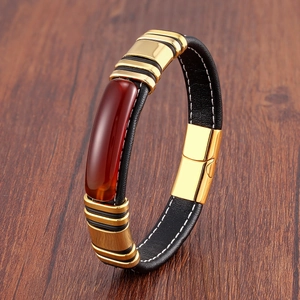 Détail d'un bracelet en cuir pour homme avec insert en pierre rouge et fermoir doré