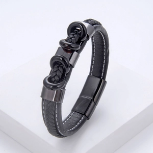 Bracelet pour homme en cuir tressé noir avec fermoir magnétique en acier sur support blanc