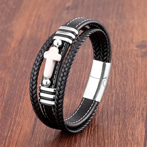 Macro détaillée d'un bracelet en cuir multicouche avec croix argentée et fermoir magnétique