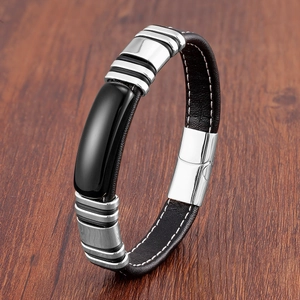 Détail d'un bracelet pour homme en cuir noir avec surpiqûres blanches et fermoir métal