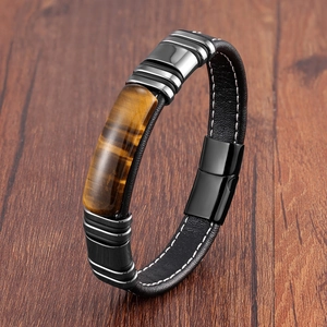 Detail of tiger eye stone insert on braided black leather bracelet with magnetic clasp
