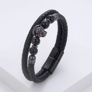 Detail of double-layer braided leather bracelet with skull charm and tiger eye beads