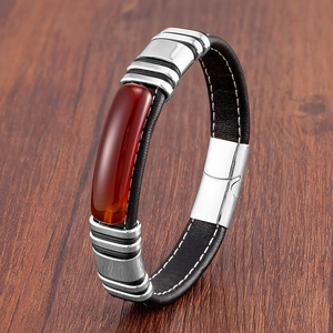 Détail macro du bracelet en cuir pour homme avec insert de pierre rouge et fermoir argenté