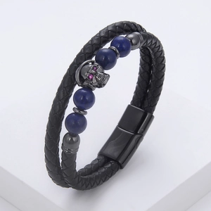 Detail of a braided leather skull bracelet with purple stones and a magnetic metal clasp