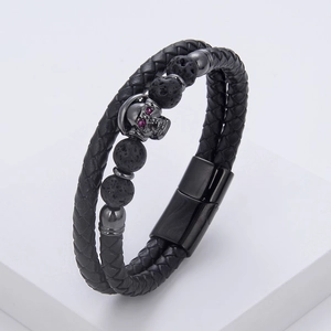 Macro detail of men's leather skull bracelet with red rhinestone eyes and magnetic clasp