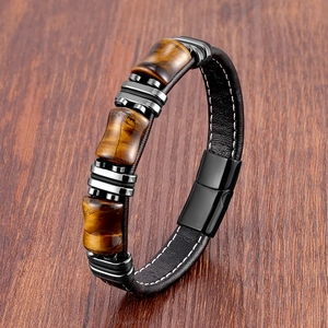 Détail d'un bracelet en cuir pour homme avec pierres œil de tigre sur fond en bois