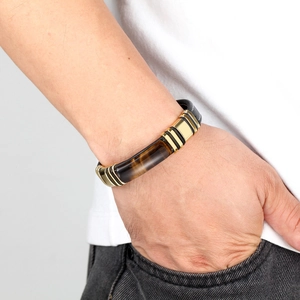 Men's leather bracelet with tiger eye stone and gold stainless steel accents on wrist