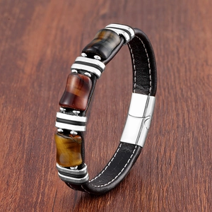 Détail d'un bracelet en cuir marron tressé orné de trois pierres d'oeil de tigre naturel