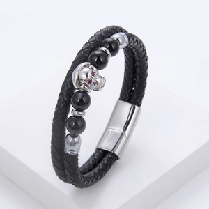 Detail of double-layer braided leather bracelet with silver skull and red stone eyes