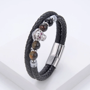 Detail of braided leather bracelet with silver skull head and natural tiger eye beads