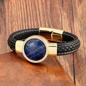 Dettaglio macro del bracciale da uomo in pelle nera intrecciata con pietra blu e fibbia oro