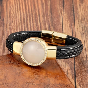 Dettaglio del bracciale in pelle intrecciata nera con metallo dorato e pietre di zircone